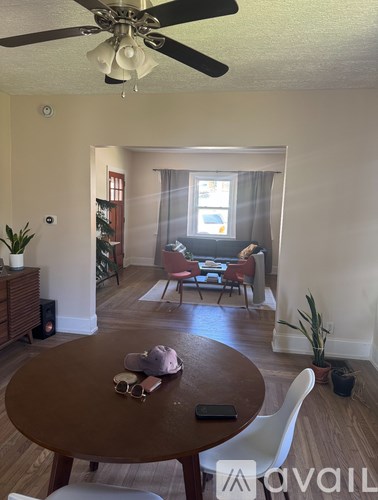 A living room with a brown table and white chairs.