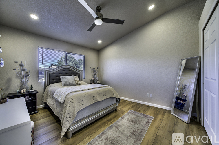 A bedroom with a large bed and a ceiling fan.