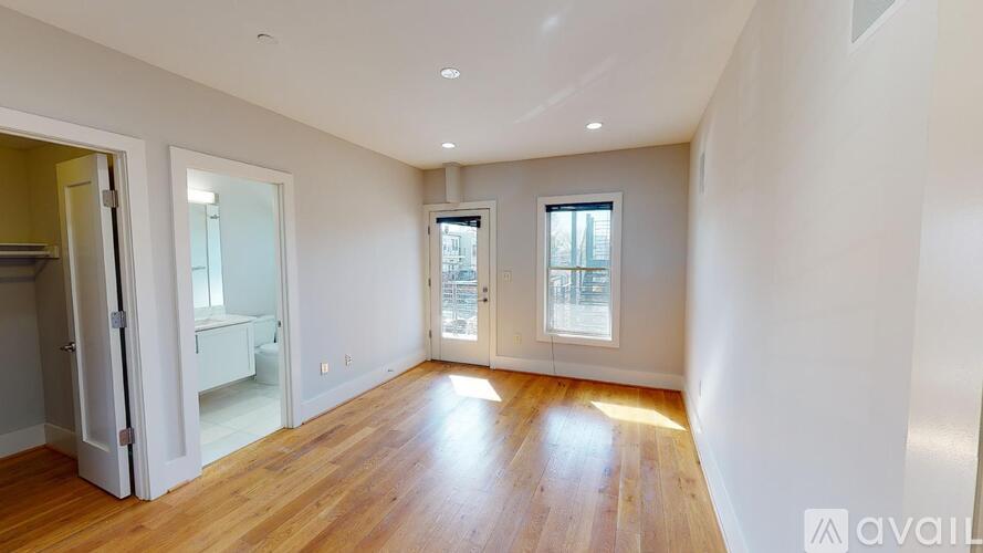 A spacious room with wooden floors and white walls.