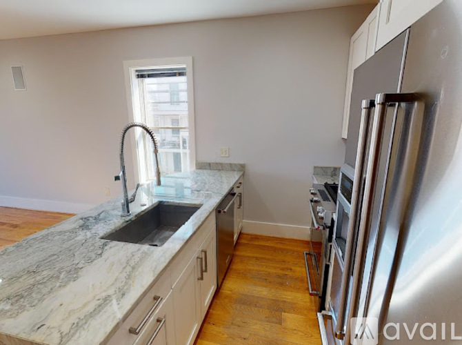 A kitchen with a marble countertop and stainless steel appliances.