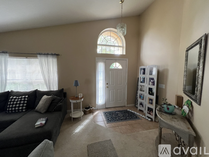 A living room with a grey couch and a white table.