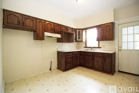 A kitchen with brown cabinets and a white door.
