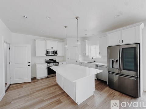 A modern kitchen with white cabinets and stainless steel appliances.
