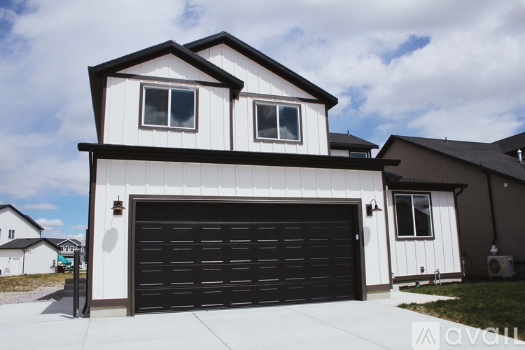 A two-story house with a black garage door.