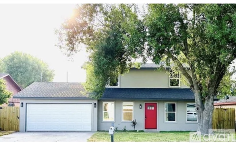 A two-story house with a red door and garage door.