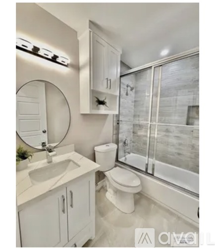 A white bathroom with a toilet, sink, and mirror.