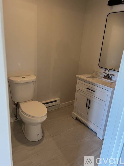A white toilet and sink in a small bathroom.