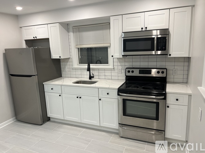 A kitchen with white cabinets and stainless steel appliances.