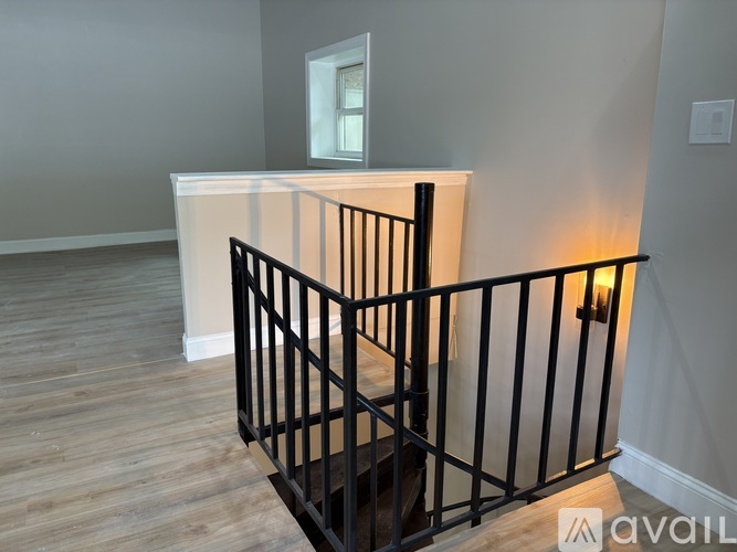 A staircase with a black railing and wooden steps.