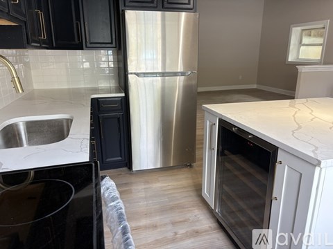 A kitchen with a stainless steel refrigerator and a white countertop.