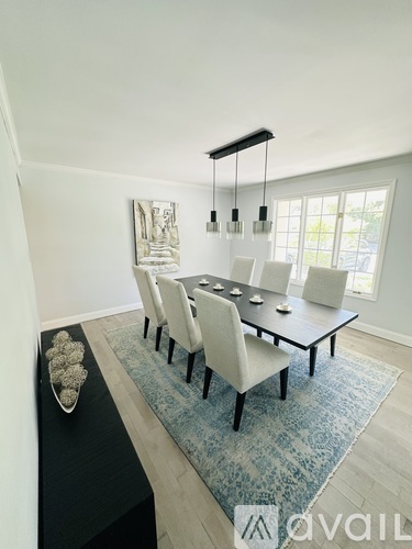A dining room with a long table and chairs.