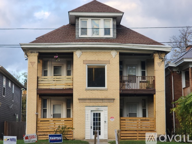 A two-story brick house with a balcony on the second floor.