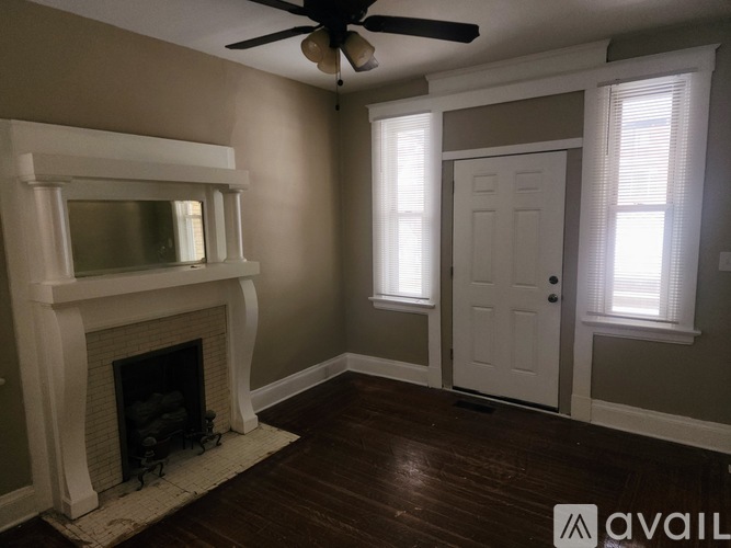 A room with a fireplace and a ceiling fan.