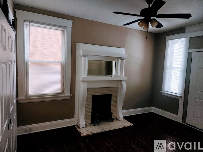 A room with a fireplace and a ceiling fan.