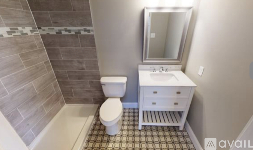 A bathroom with a toilet, sink, and mirror.