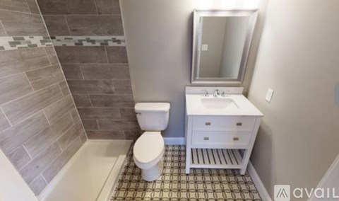 A bathroom with a toilet, sink, and mirror.