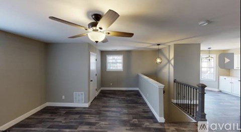A spacious room with a ceiling fan and a window.