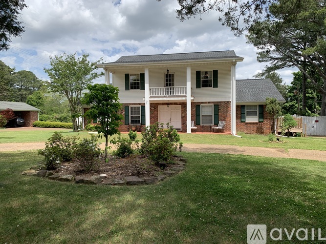 A house with a front yard and a tree in the front.