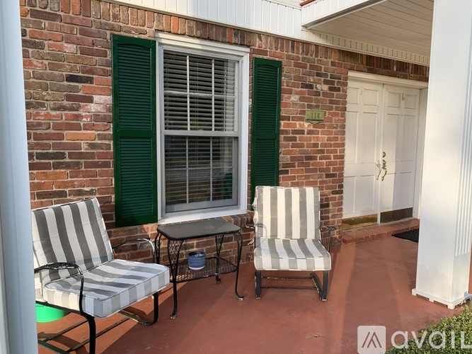 A patio with two striped chairs and a table.