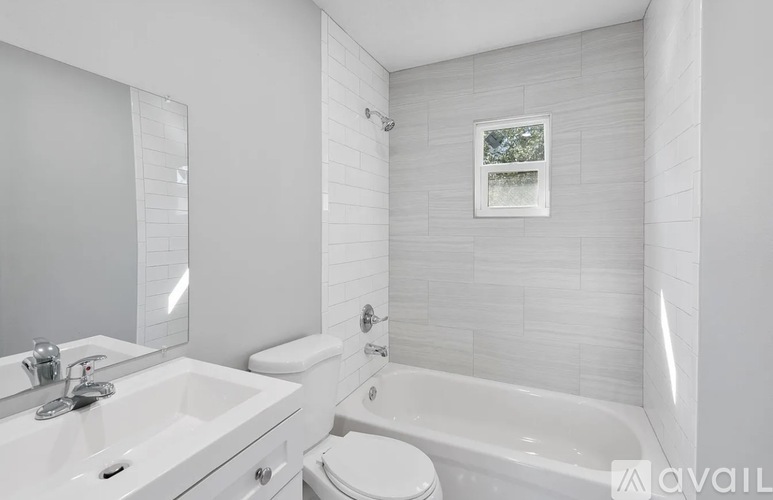 A white bathroom with a toilet, sink, and bathtub.