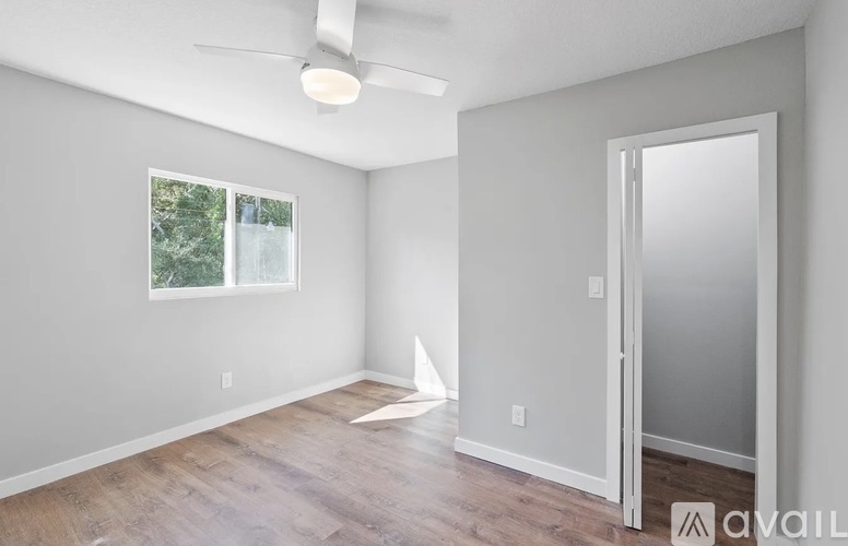 A room with a ceiling fan and a door.