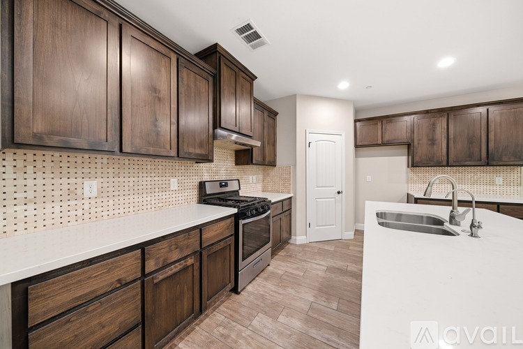 A kitchen with dark wood cabinets and a white countertop.