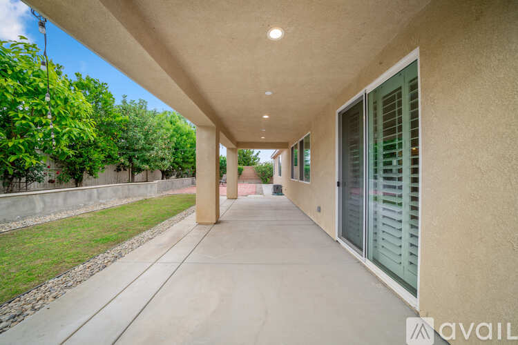 A long concrete walkway leads to a building with a glass door.