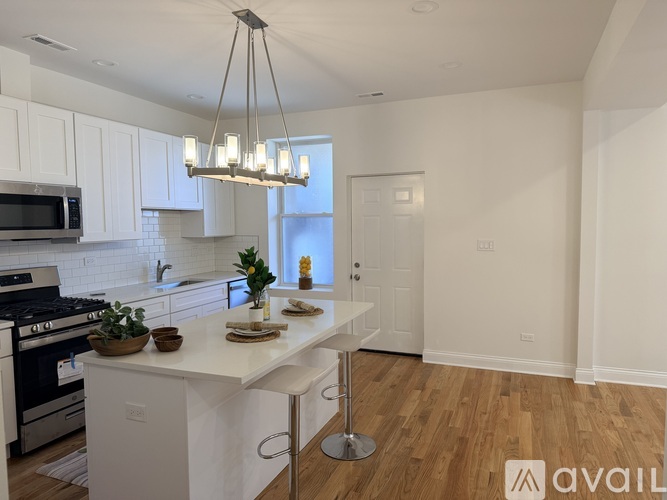 A modern kitchen with white cabinets and a central island.