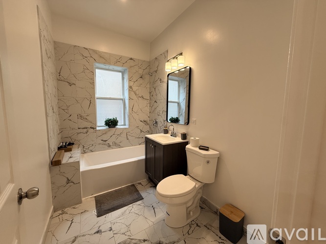 A bathroom with a marble floor and a window.