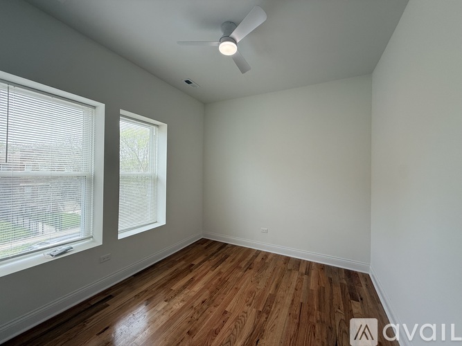 A room with wooden floors and a ceiling fan.