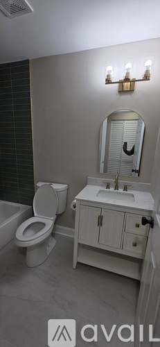 A bathroom with a toilet, sink, and mirror.