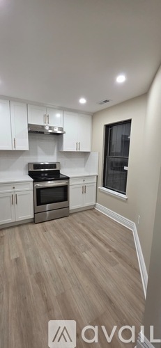 A kitchen with white cabinets and a wooden floor.