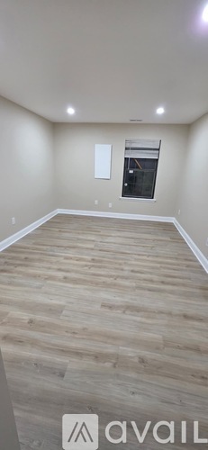 A room with wooden flooring and a window.