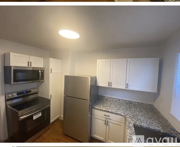 A kitchen with white cabinets and a granite countertop.