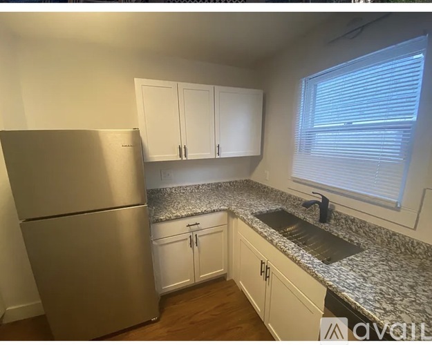 A kitchen with a granite countertop and stainless steel appliances.