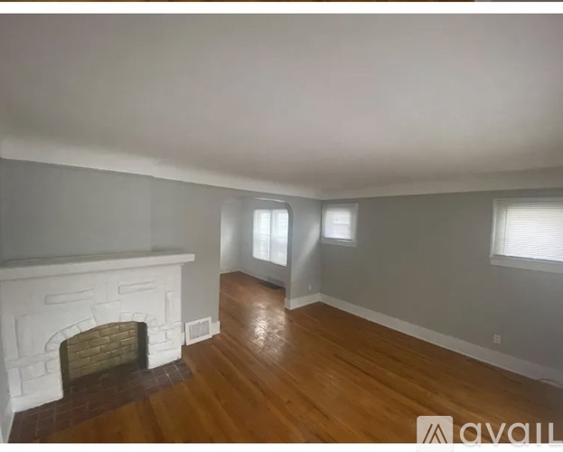 A room with a fireplace and wood flooring.