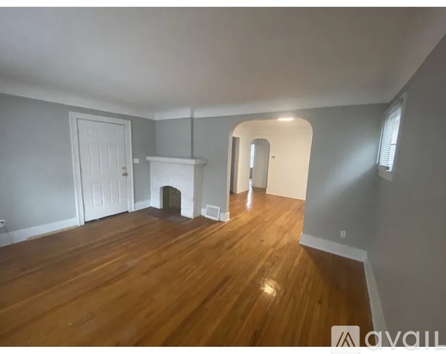 A room with wooden floors and a fireplace.