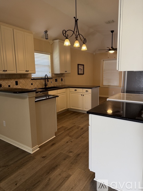 A kitchen with wooden cabinets and black countertops.