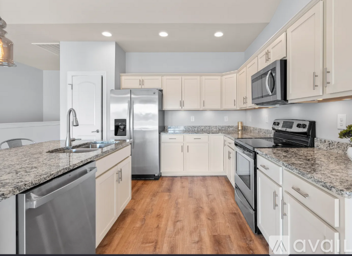 A kitchen with white cabinets and a granite countertop.