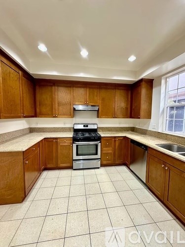 A kitchen with wooden cabinets and a tiled floor.