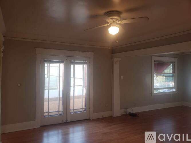 A room with a ceiling fan and a window with blinds.