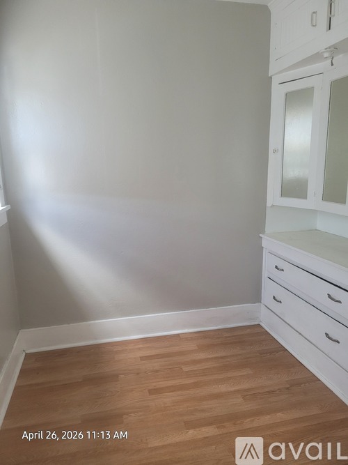 A room with wooden flooring and white walls.