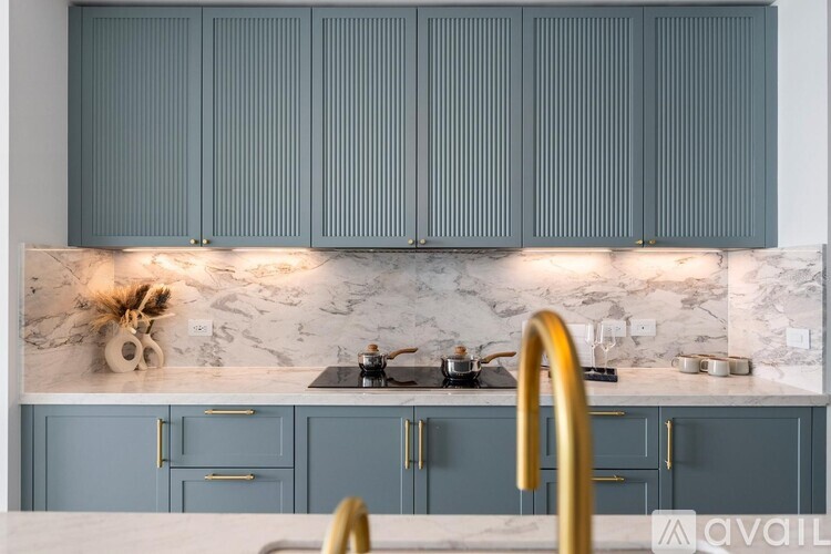 A kitchen with blue cabinets and a marble countertop.