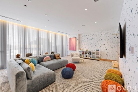 A living room with grey couches and a white wall with black spots.