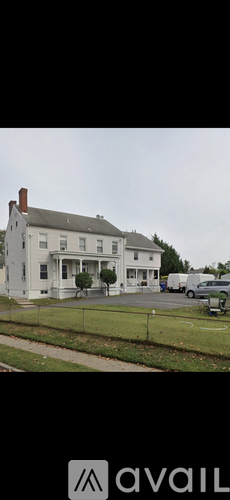 A white house with a black roof and a chimney is shown.