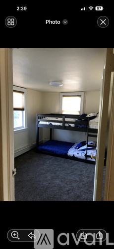 A bedroom with a bunk bed and a window.
