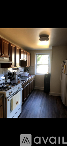 A kitchen with wooden cabinets and a white stove top oven.
