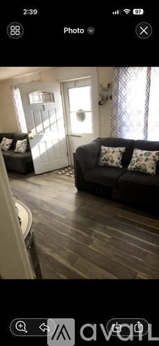 A living room with a grey couch and a white door.