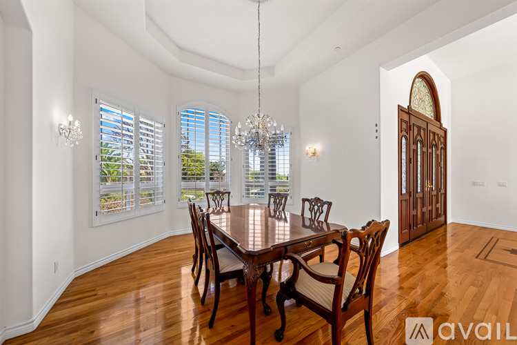 A dining room with a wooden table and chairs.