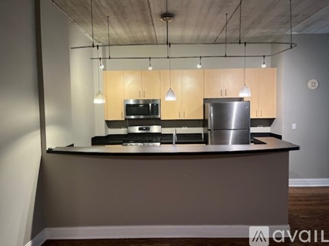 A modern kitchen with a stainless steel refrigerator and a microwave oven.